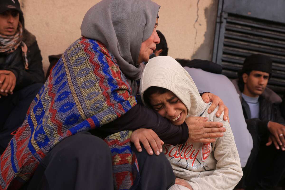 Palestinians mourn after three members of the Al-Rjodi family were killed in an Israeli strike in Deir al-Balah in the central Gaza Strip on January 21, 2026.