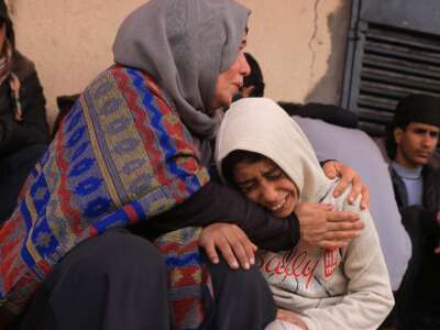 Palestinians mourn after three members of the Al-Rjodi family were killed in an Israeli strike in Deir al-Balah in the central Gaza Strip on January 21, 2026.