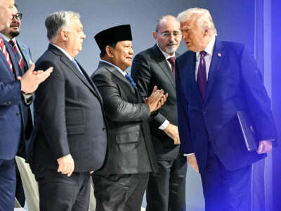 U.S. President Donald Trump walks past Hungary's Prime Minister Viktor Orban, Indonesia's President Prabowo Subianto, and Jordan's Foreign Minister Ayman Safadi as he arrives at the "Board of Peace" meeting during the World Economic Forum annual meeting in Davos, Switzerland, on January 22, 2026.