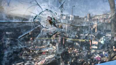 A gunshot perforation can be seen in a window in front of a makeshift memorial for Alex Pretti on January 26, 2026, in Minneapolis, Minnesota.