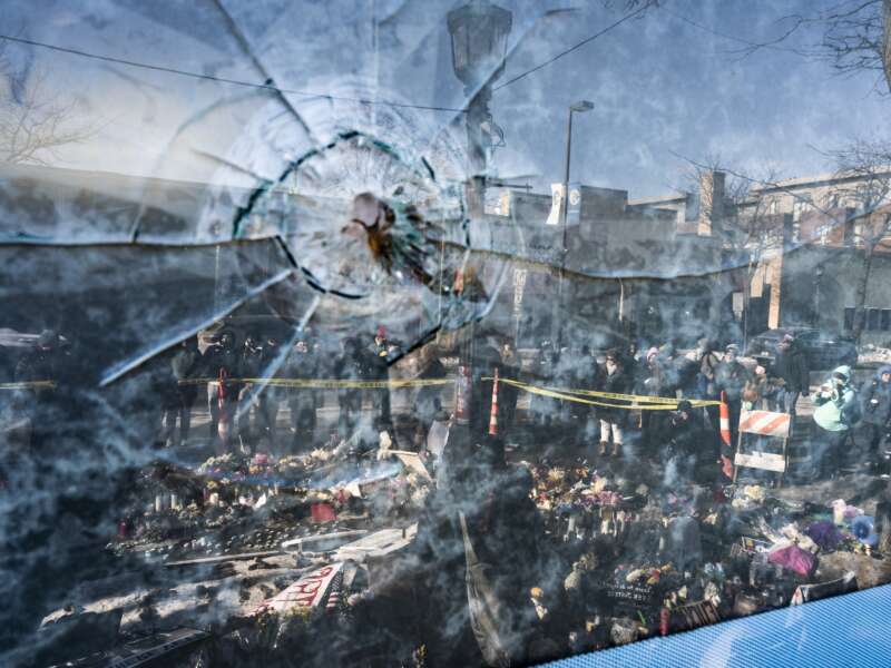 A gunshot perforation can be seen in a window in front of a makeshift memorial for Alex Pretti on January 26, 2026, in Minneapolis, Minnesota.