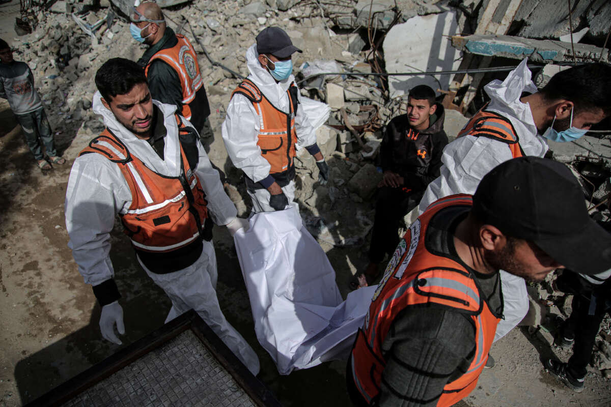 Forensic and civil defense teams recover the bodies of Palestinians killed in Israeli strikes from a temporary burial ground at Selahaddin mosque on January 25, 2026, in Gaza City, preparing them for reburial in formal cemeteries.