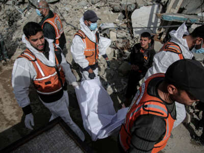 Forensic and civil defense teams recover the bodies of Palestinians killed in Israeli strikes from a temporary burial ground at Selahaddin mosque on January 25, 2026, in Gaza City, preparing them for reburial in formal cemeteries.