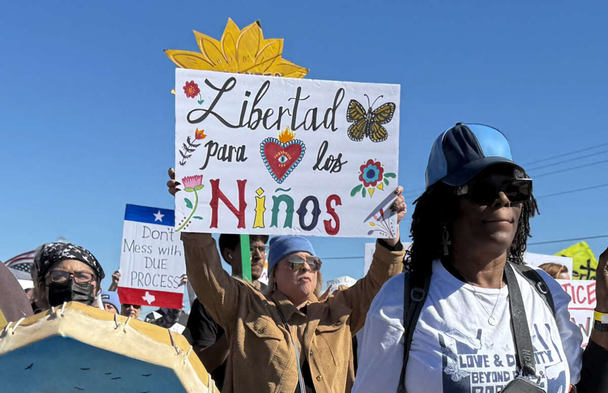 A protester holds a sign calling for freedom for children during a demonstration and vigil outside the South Texas Family Residential Center in Dilley, Texas, on January 28, 2026.