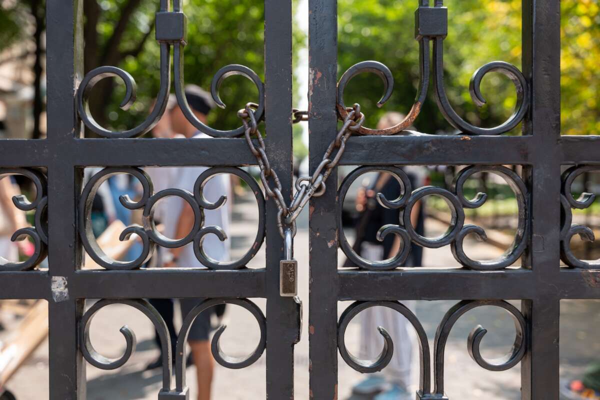 Gates are locked as students, faculty, and others wait to enter Columbia University's campus on August 15, 2024, in New York City, after the school instituted new security rules before the start of the academic year.
