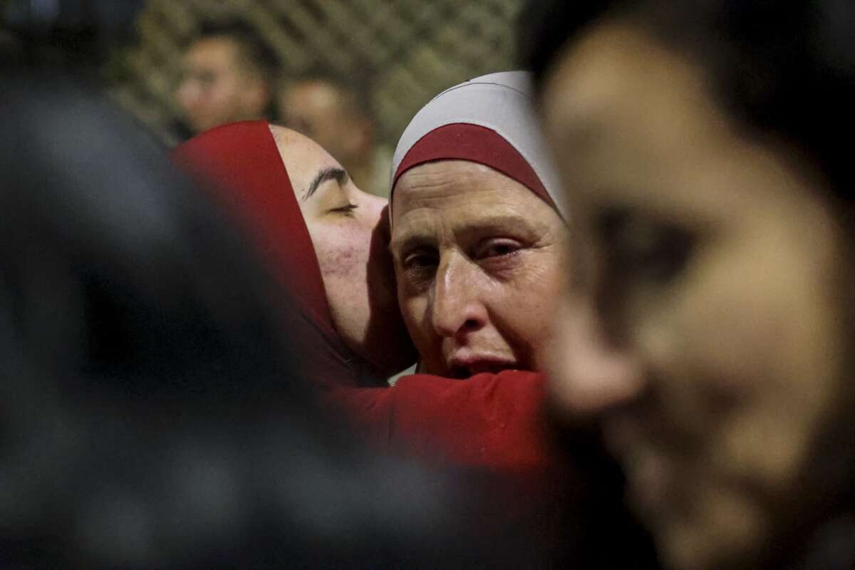 A Palestinian woman cries as she embraces a loved one who was released from an Israeli jail in the early hours of January 20, 2025, in the occupied West Bank town of Beitunia, on the outskirts of Ramallah.