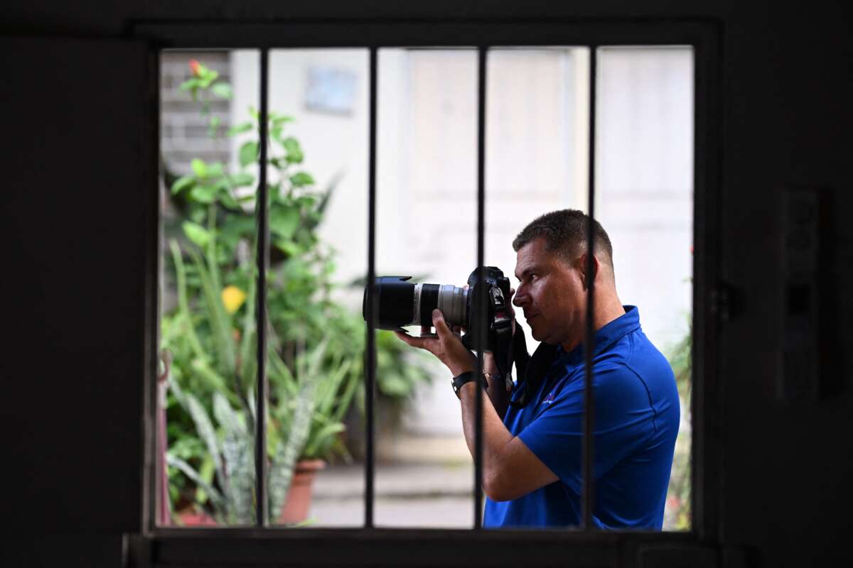 Salvadoran journalist Mario Guevara, 48, deported from the United States, is photographed holding his camera at a family member's house in Apopa, El Salvador, on October 6, 2025.