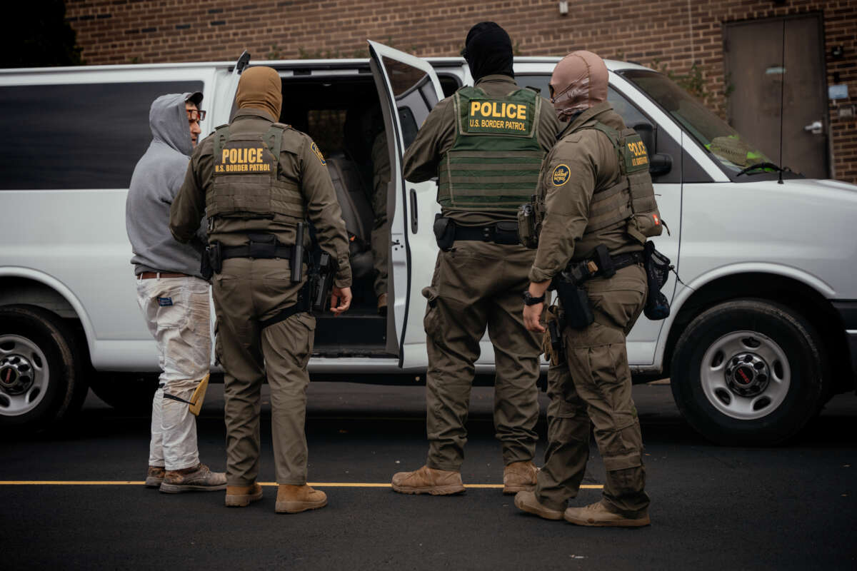 People detained earlier in the day are taken to a parking lot on the far north side of the city before being transferred to an Immigration and Customs Enforcement facility on October 31, 2025, in Chicago, Illinois.