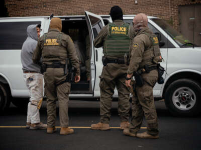 People detained earlier in the day are taken to a parking lot on the far north side of the city before being transferred to an Immigration and Customs Enforcement facility on October 31, 2025, in Chicago, Illinois.