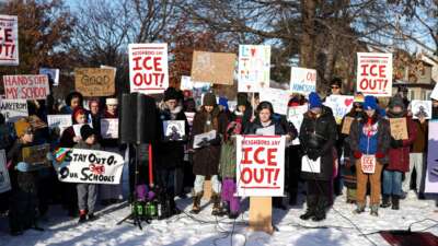 People pause for a minute of silence during a press conference organized by the group "Minneapolis Families for Public Schools," in Minneapolis, Minnesota, on January 9, 2026.