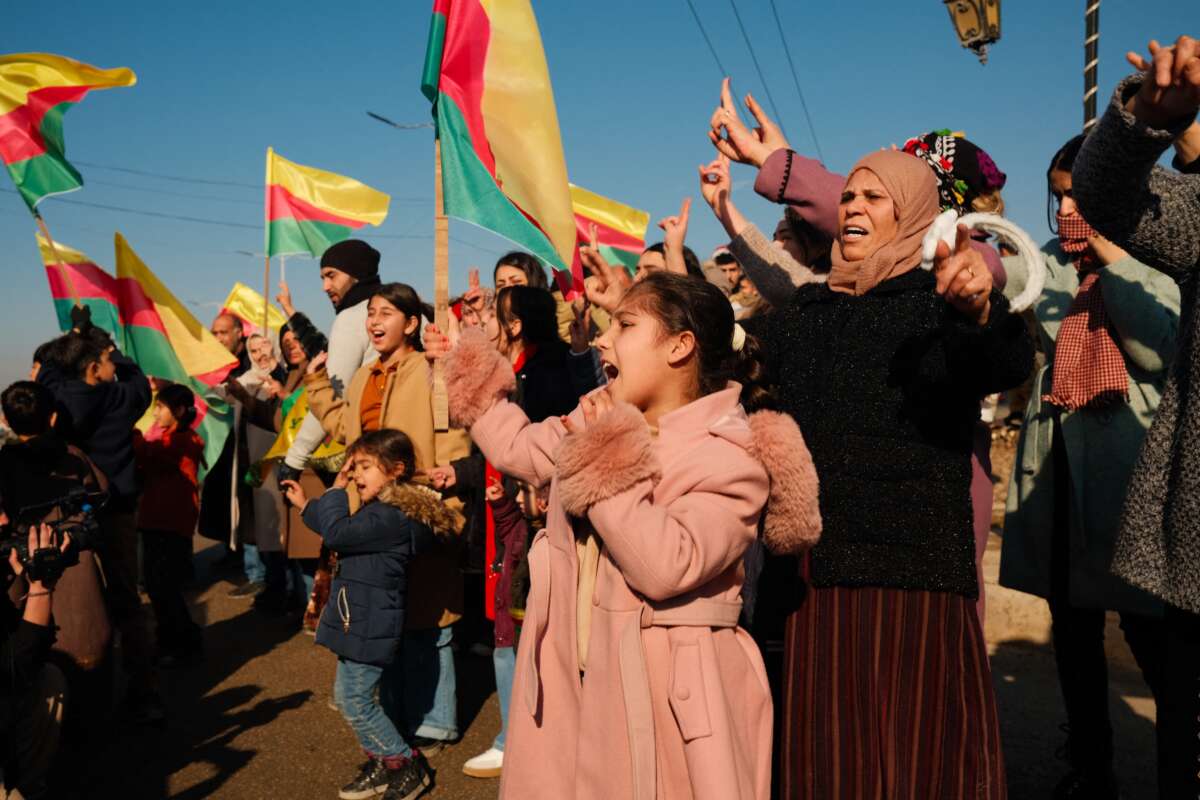 People wave the flag of Rojava to celebrate the extension of a ceasefire allowing for citizens who fled their homes to return, on January 25, 2026, in Al-Hasakah, in the Autonomous Administration of North and East Syria.