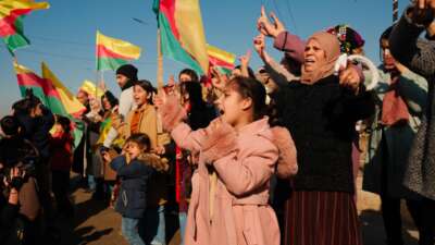 People wave the flag of Rojava to celebrate the extension of a ceasefire allowing for citizens who fled their homes to return, on January 25, 2026, in Al-Hasakah, in the Autonomous Administration of North and East Syria.