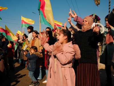 People wave the flag of Rojava to celebrate the extension of a ceasefire allowing for citizens who fled their homes to return, on January 25, 2026, in Al-Hasakah, in the Autonomous Administration of North and East Syria.