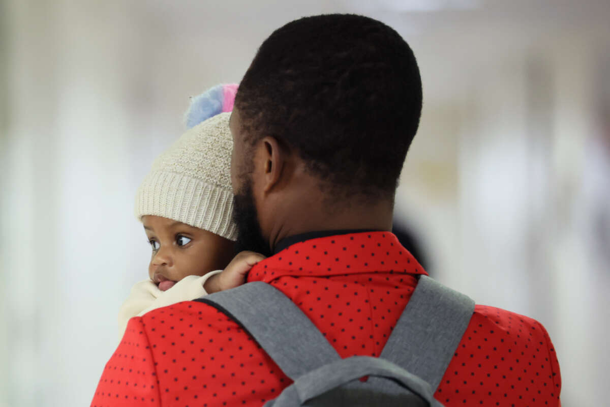 A person holding a baby leaves a waiting room after a cancellation of their appointment in immigration court at the Jacob K. Javits Federal Building on February 4, 2026, in New York City.