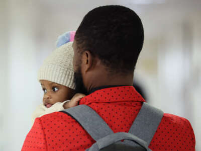 A person holding a baby leaves a waiting room after a cancellation of their appointment in immigration court at the Jacob K. Javits Federal Building on February 4, 2026, in New York City.
