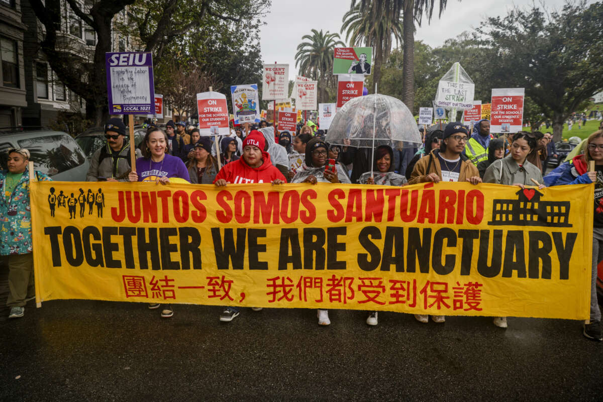 President of the United Teachers Los Angeles, Cecily Myart-Cruz, center in red, marches with hundreds of educators, school staff, students, and families in the second day of city-wide protests to support union leaders as they face off with SFUSD officials in San Francisco, California, on February 10, 2026. "We are fighting for the soul of San Francisco," said Myart-Cruz, who flew from Los Angeles to support the protests.
