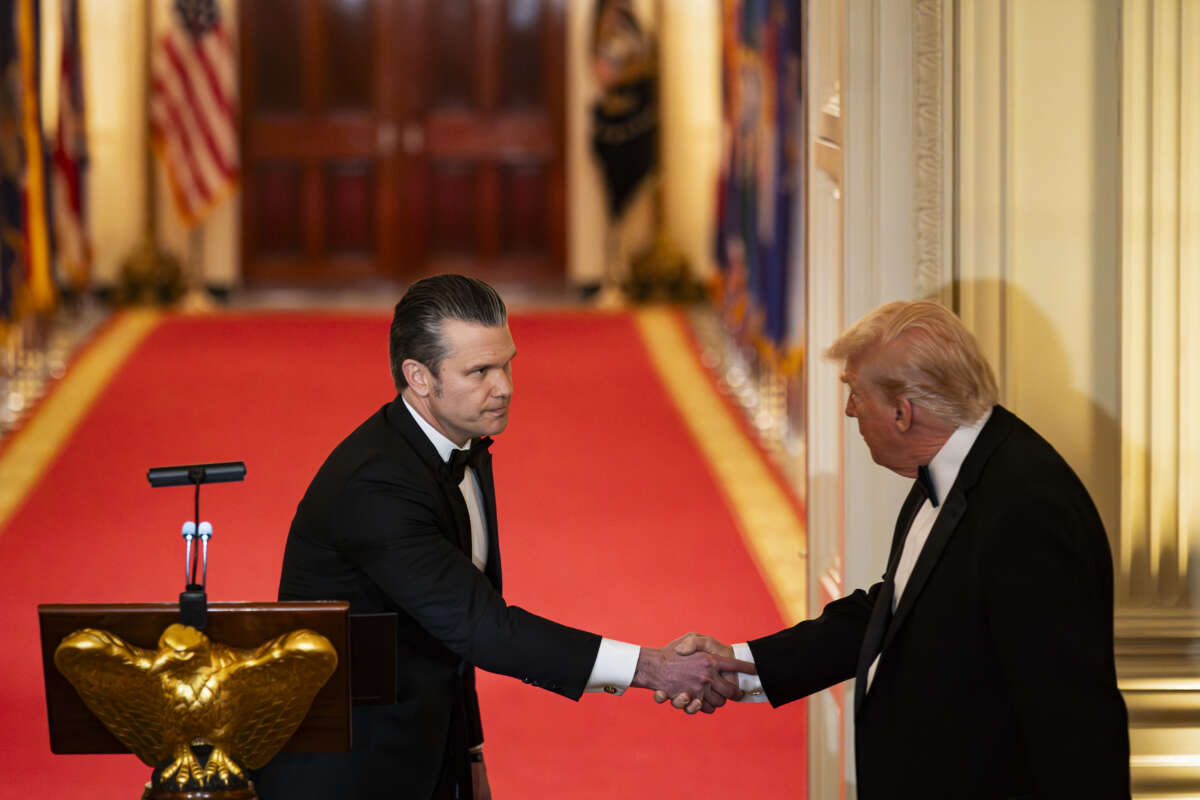 U.S. President Donald Trump shakes hands with U.S. Secretary of Defense Pete Hegseth during the National Governors Association Evening Dinner and Reception in the East Room of the White House on February 21, 2026, in Washington, D.C.