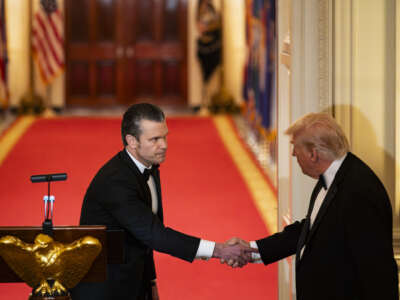U.S. President Donald Trump shakes hands with U.S. Secretary of Defense Pete Hegseth during the National Governors Association Evening Dinner and Reception in the East Room of the White House on February 21, 2026, in Washington, D.C.
