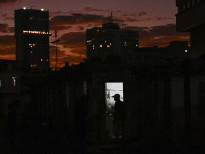 The silhouette of a man is seen at his home during a blackout in Havana, Cuba, on February 21, 2026. On February 23, Cuban Foreign Minister Bruno Rodríguez Parrilla said the United States was trying to trigger a "humanitarian catastrophe" in his country with an oil blockade he called an "aggressive escalation."