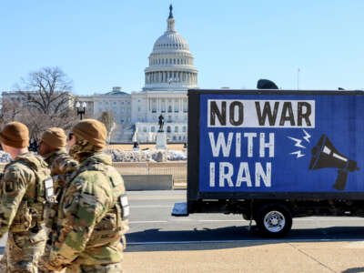 A group of National Guardsmen walk past the Win Without War Billboard Truck displaying the message "No War With Iran" in front of the U.S. Capitol on February 24, 2026, in Washington, D.C.
