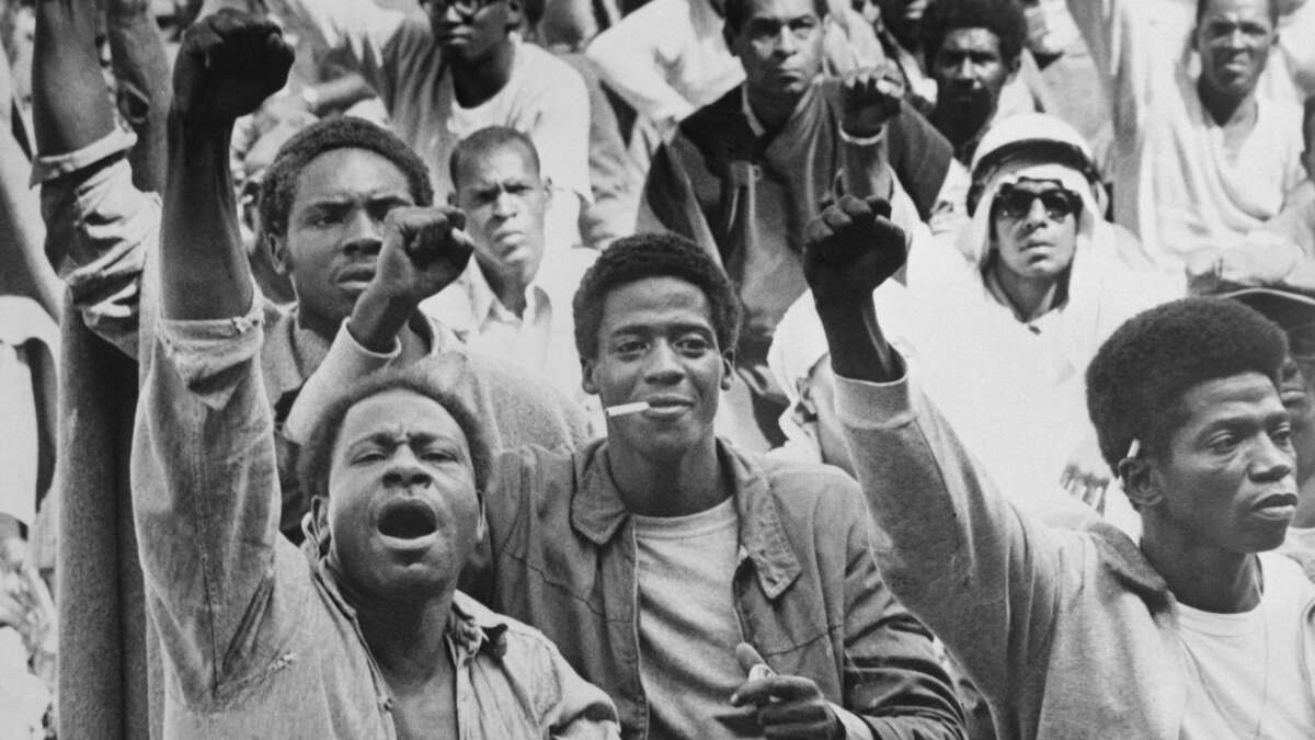 Prisoners at the Attica Correctional Facility give the Black Power salute on September 10, 1971. “I believe the connection between abolition and Black anti-fascism is crystallized in the writings and activism of political prisoners and prison abolitionists,” says scholar Jeanelle K. Hope. “The Attica prison uprising of 1971 stands as a major inflection point in this history.”