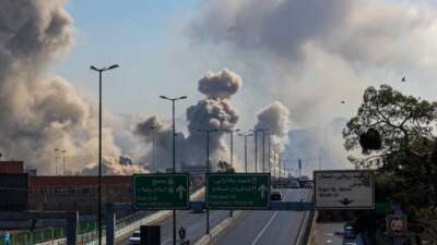 Motorists drive along an expressway as plumes of smoke rise after strikes on Tehran on March 5, 2026.