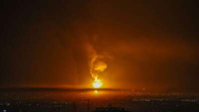 Smoke and flames rise at the site of airstrikes on an oil depot in Tehran on March 7, 2026.