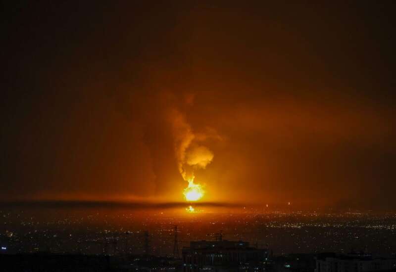 Smoke and flames rise at the site of airstrikes on an oil depot in Tehran on March 7, 2026.