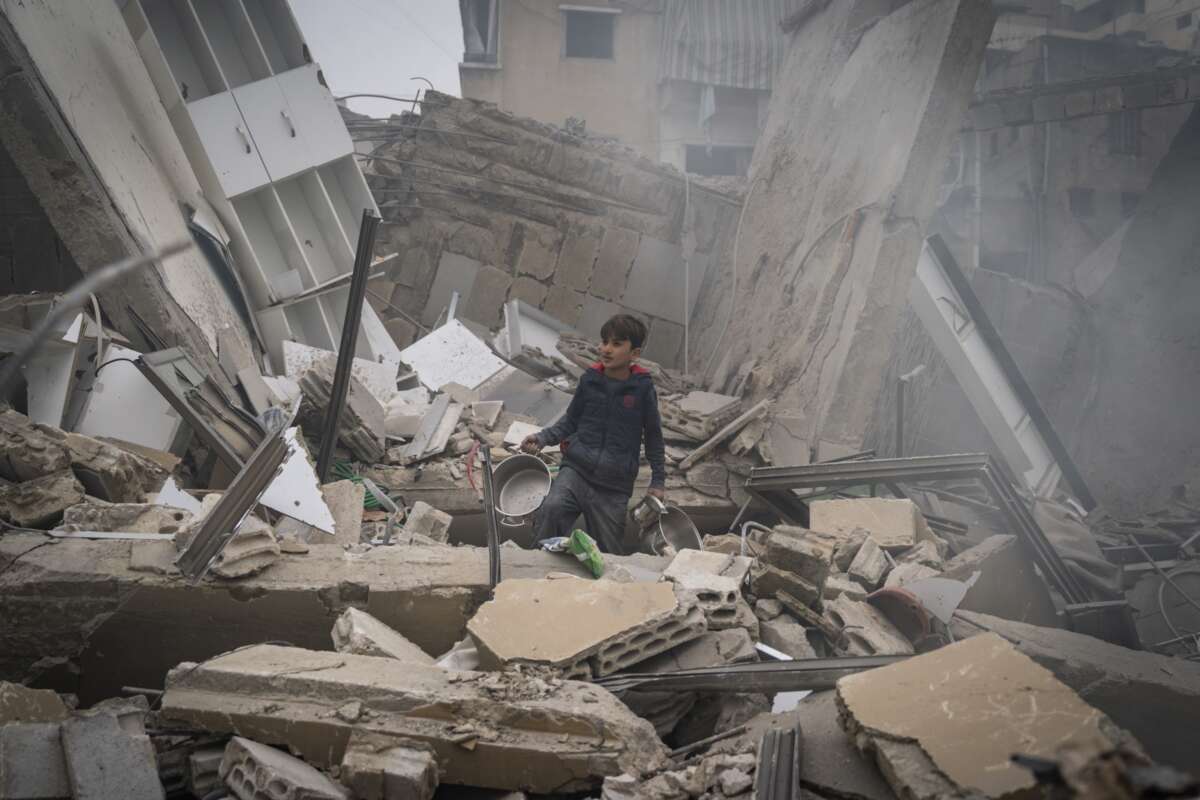 A child searches for kitchen tools inside of the debris of a building that has collapsed after an IDF airstrike on March 18, 2026 in Beirut, Lebanon.