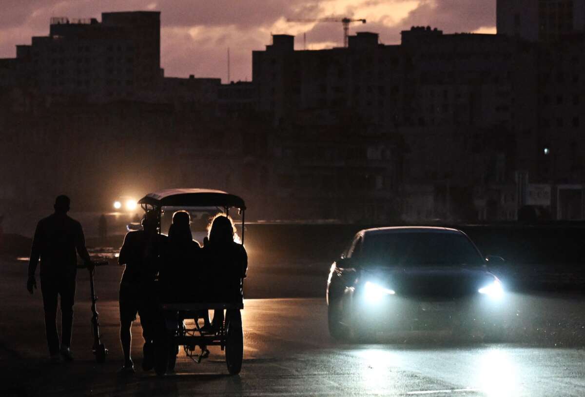 People transit on a street without power during a nationwide blackout in Havana on March 21, 2026.
