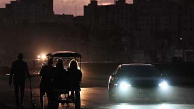People transit on a street without power during a nationwide blackout in Havana on March 21, 2026.