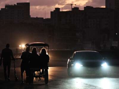People transit on a street without power during a nationwide blackout in Havana on March 21, 2026.