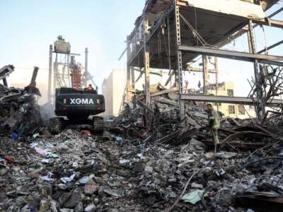 A firefighter stands on the rubble of residential buildings near Niloufar square in Tehran during the ongoing joint U.S.-Israeli military campaign on Iran on March 2, 2026.