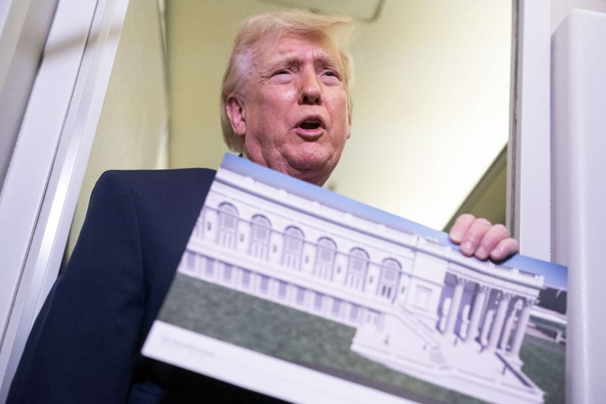 U.S. President Donald Trump holds a rendering of the White House ballroom while speaking to members of the media onboard Air Force One on March 29, 2026.