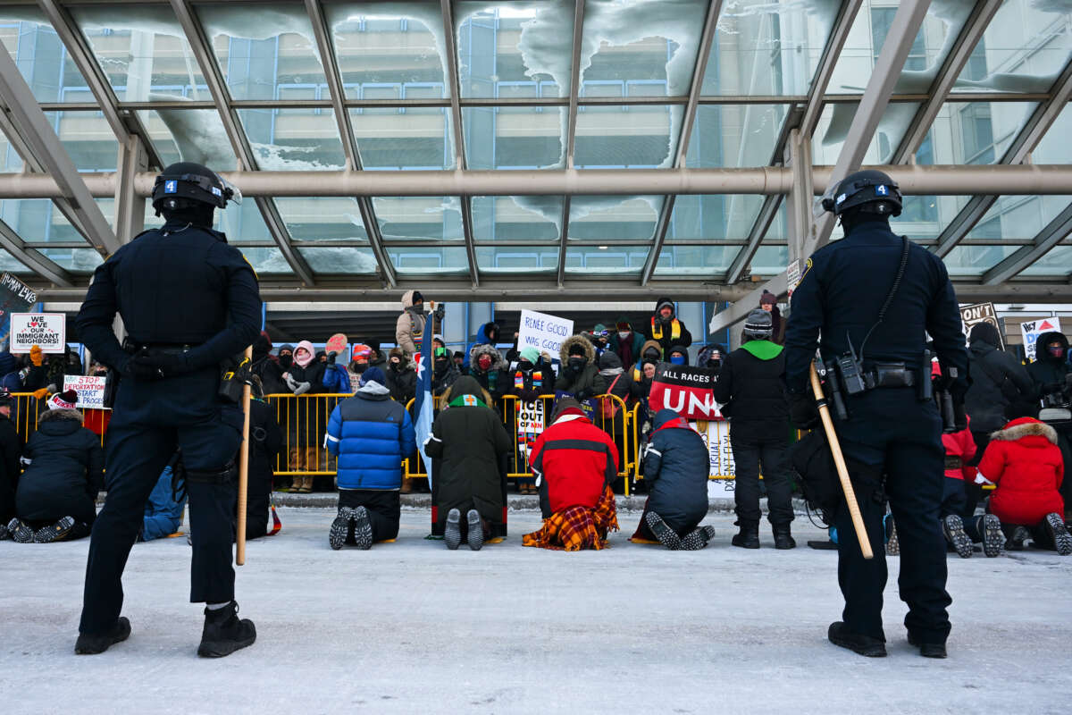 Police look on as people attend a demonstration at the Minneapolis-Saint Paul International Airport amid a surge of federal immigration authorities in the area in St. Paul, Minnesota.