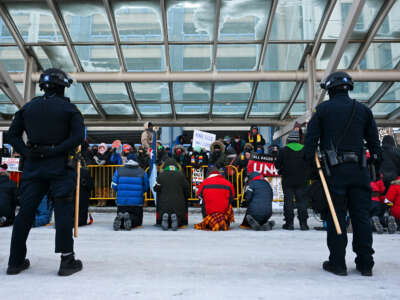 Police look on as people attend a demonstration at the Minneapolis-Saint Paul International Airport amid a surge of federal immigration authorities in the area in St. Paul, Minnesota.