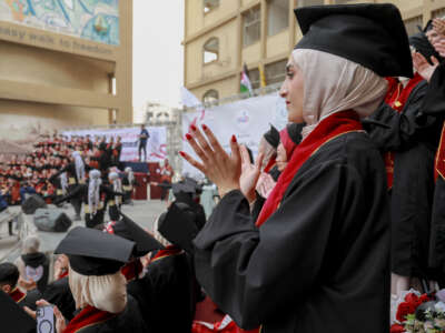 Graduates applaud during a graduation ceremony at Al-Azhar University in Gaza City, on February 9, 2026. University officials said the graduation reflects the continuation of academic programs despite repeated damage to infrastructure and limited resources, as graduates prepare to enter the healthcare sector in a territory facing severe medical shortages.
