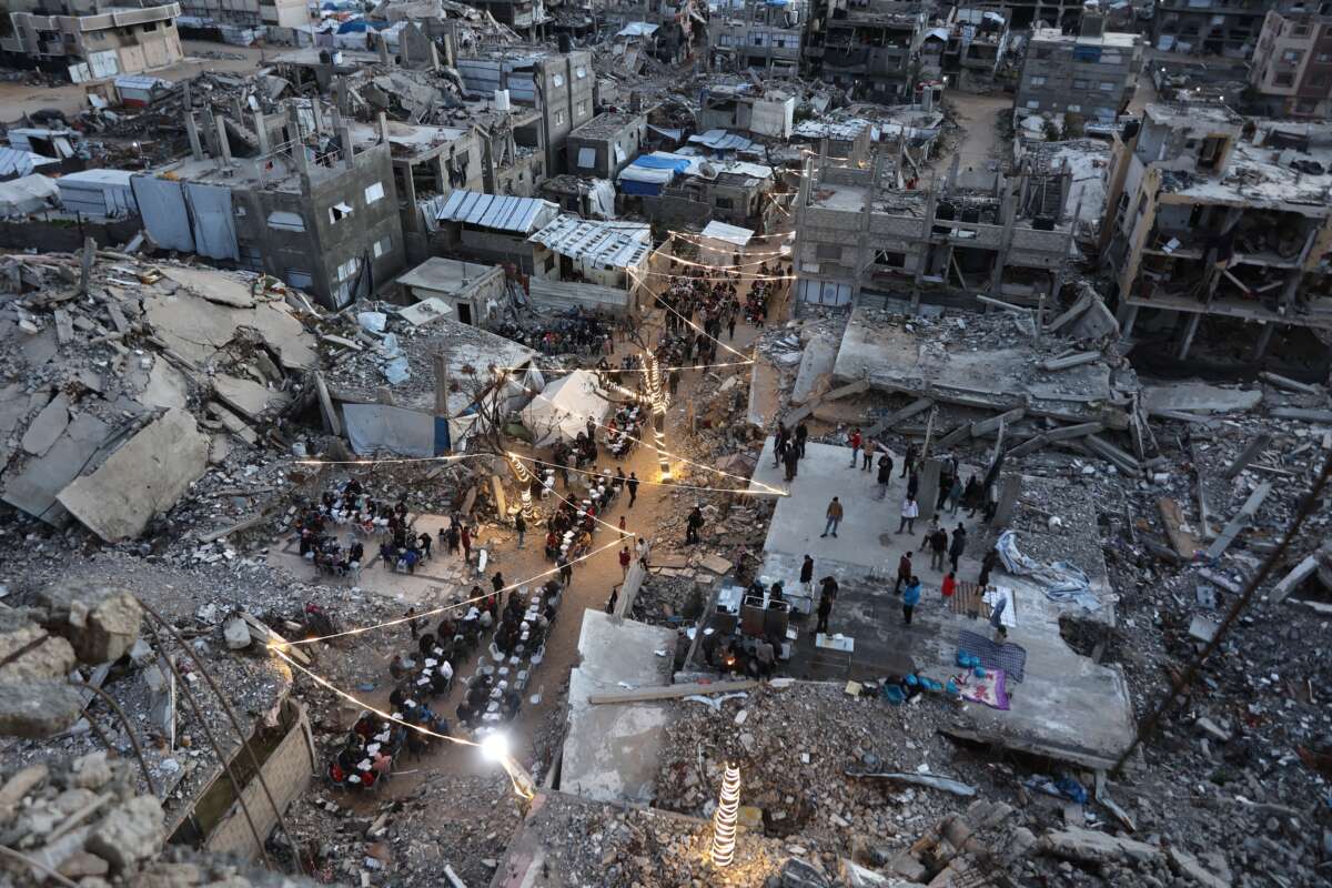 Displaced Palestinians gather for their fast-breaking iftar meal amid the rubble of destroyed buildings at the Jabalia refugee camp in the northern Gaza Strip, during the Muslim holy fasting month of Ramadan, on February 23, 2026.