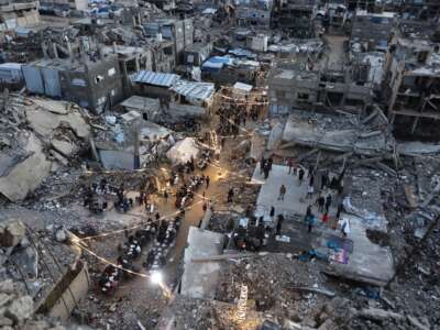 Displaced Palestinians gather for their fast-breaking iftar meal amid the rubble of destroyed buildings at the Jabalia refugee camp in the northern Gaza Strip, during the Muslim holy fasting month of Ramadan, on February 23, 2026.