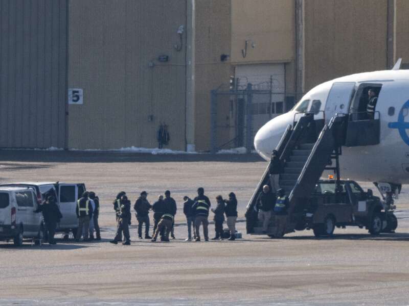 ICE agents look on as deportees are screened before boarding a GlobeX plane at Minneapolis-St. Paul International Airport on February 24, 2026, in Minneapolis, Minnesota.