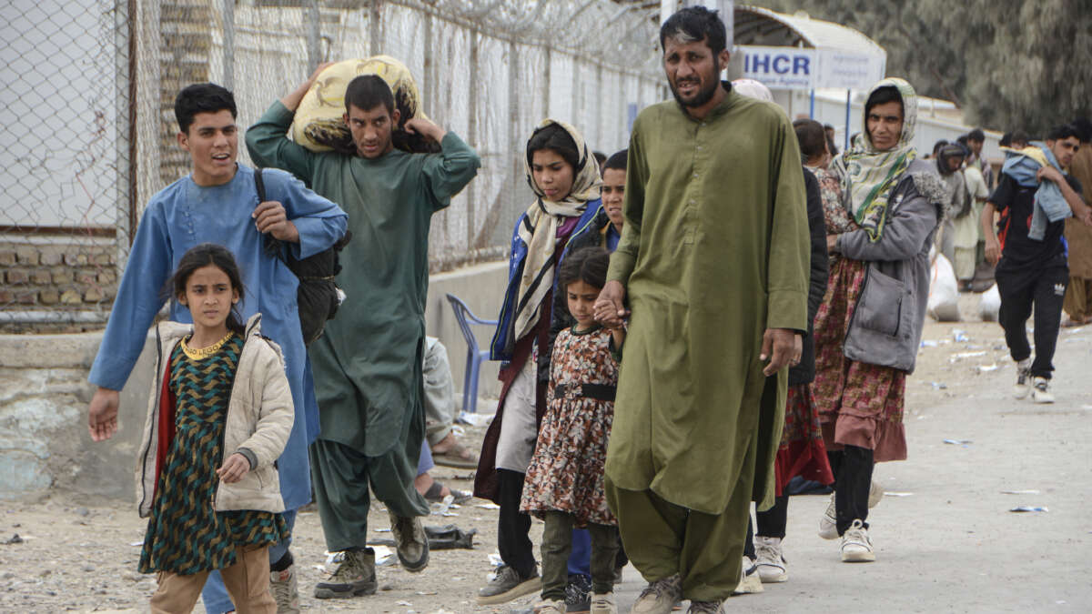 Afghan nationals walk near the Pul-e Abresham, or the Silk Bridge, after returning from Iran at the Afghanistan-Iran border crossing in Zaranj, Nimruz province, on March 2, 2026.