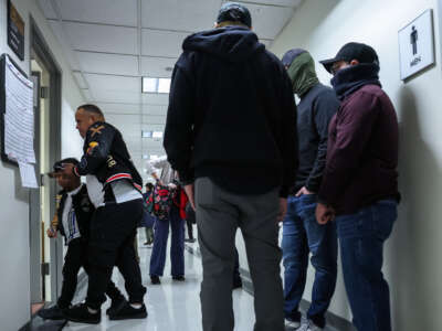 A man from Venezuela walks in to his court hearing with his son as federal agents patrol the halls of immigration court at the Jacob K. Javits Federal Building on March 5, 2026 in New York City.