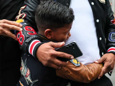 A child cries as he holds his father, a man from Venezuela, after they were detained and released after leaving immigration court at the Jacob K. Javits Federal Building on March 5, 2026, in New York City.
