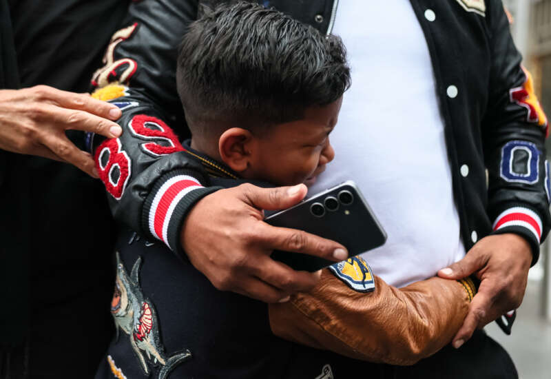 A child cries as he holds his father, a man from Venezuela, after they were detained and released after leaving immigration court at the Jacob K. Javits Federal Building on March 5, 2026, in New York City.