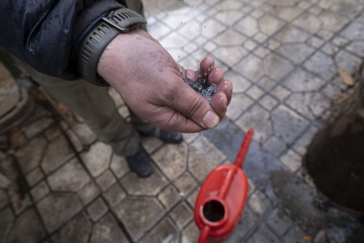 An Iranian man tries to show dark water polluted by oil-soot residue from Tehran's petroleum storage facilities, which were struck during the U.S.-Israeli military campaign, in Tehran, Iran, on March 8, 2026.