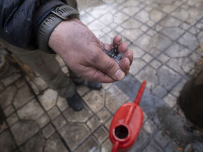 An Iranian man tries to show dark water polluted by oil-soot residue from Tehran's petroleum storage facilities, which were struck during the U.S.-Israeli military campaign, in Tehran, Iran, on March 8, 2026.