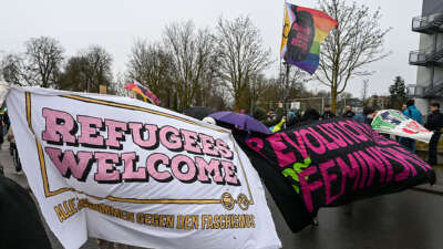 Counter demonstrators hold up a “refugees welcome” banner