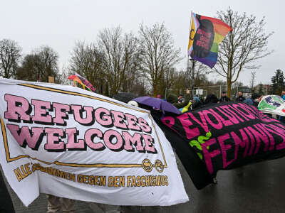 Counter demonstrators hold up a “refugees welcome” banner