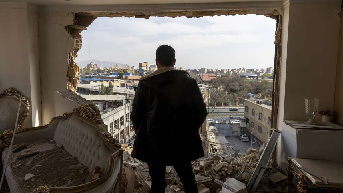 A man stands in a damaged residence at the site of buildings that were destroyed in an airstrike in the Khani Abad neighbourhood of Tehran, Iran, on March 14, 2026.