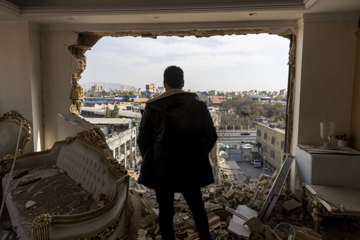 A man stands in a damaged residence at the site of buildings that were destroyed in an airstrike in the Khani Abad neighbourhood of Tehran, Iran, on March 14, 2026.